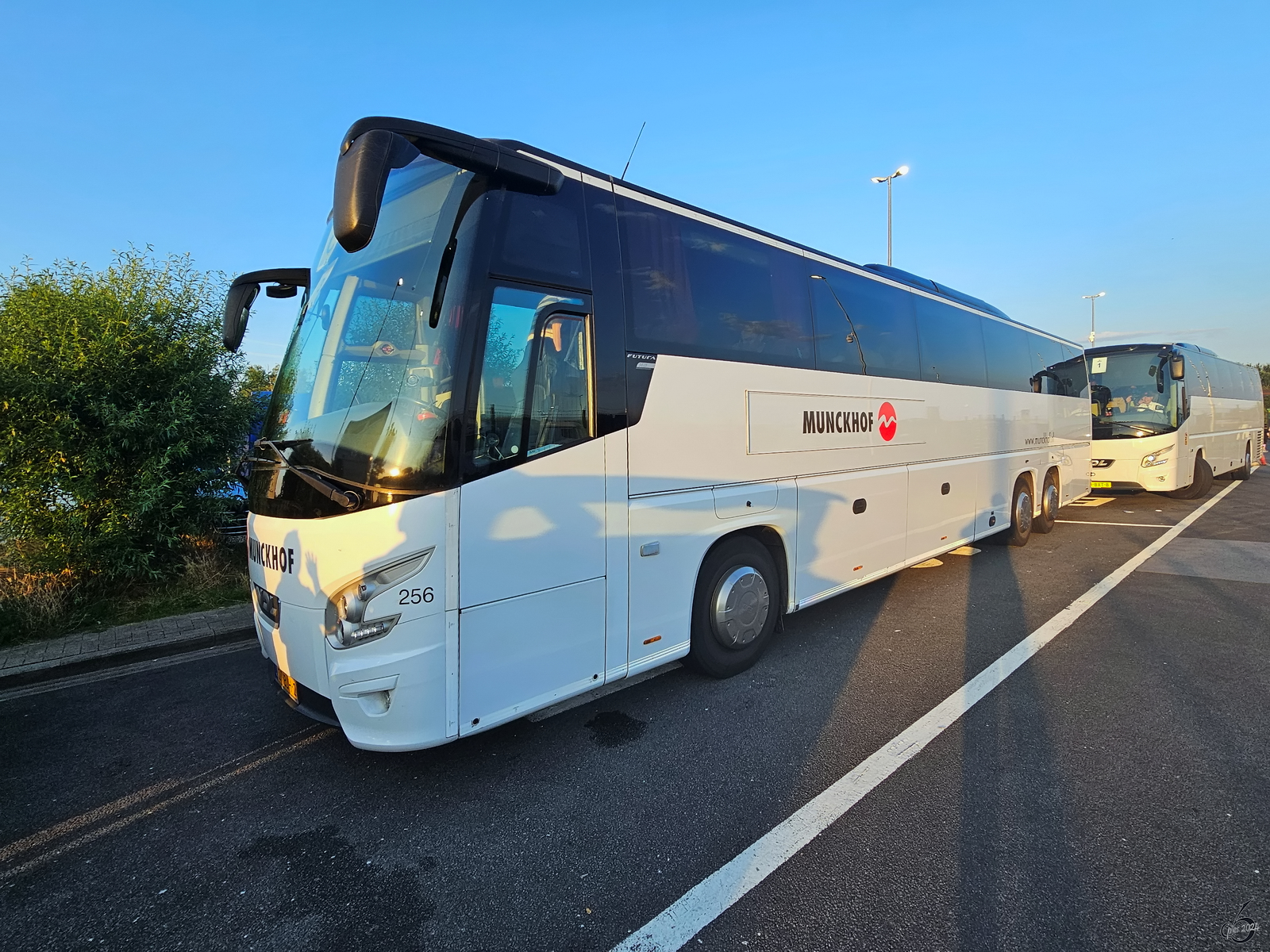 Diese beiden VDL Futura Reisebusse werden von der Niederländischen Munckhof Groep betrieben, so gesehen Mitte Juli 2024 auf einem belgischen Autobahnrastplatz.